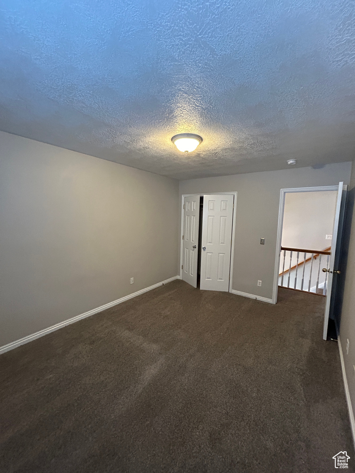 3rd Bedroom with dark carpet and a textured ceiling