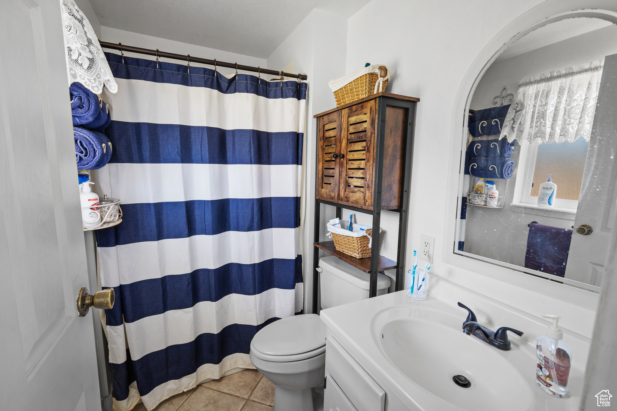 Bathroom featuring toilet, tile flooring, and vanity