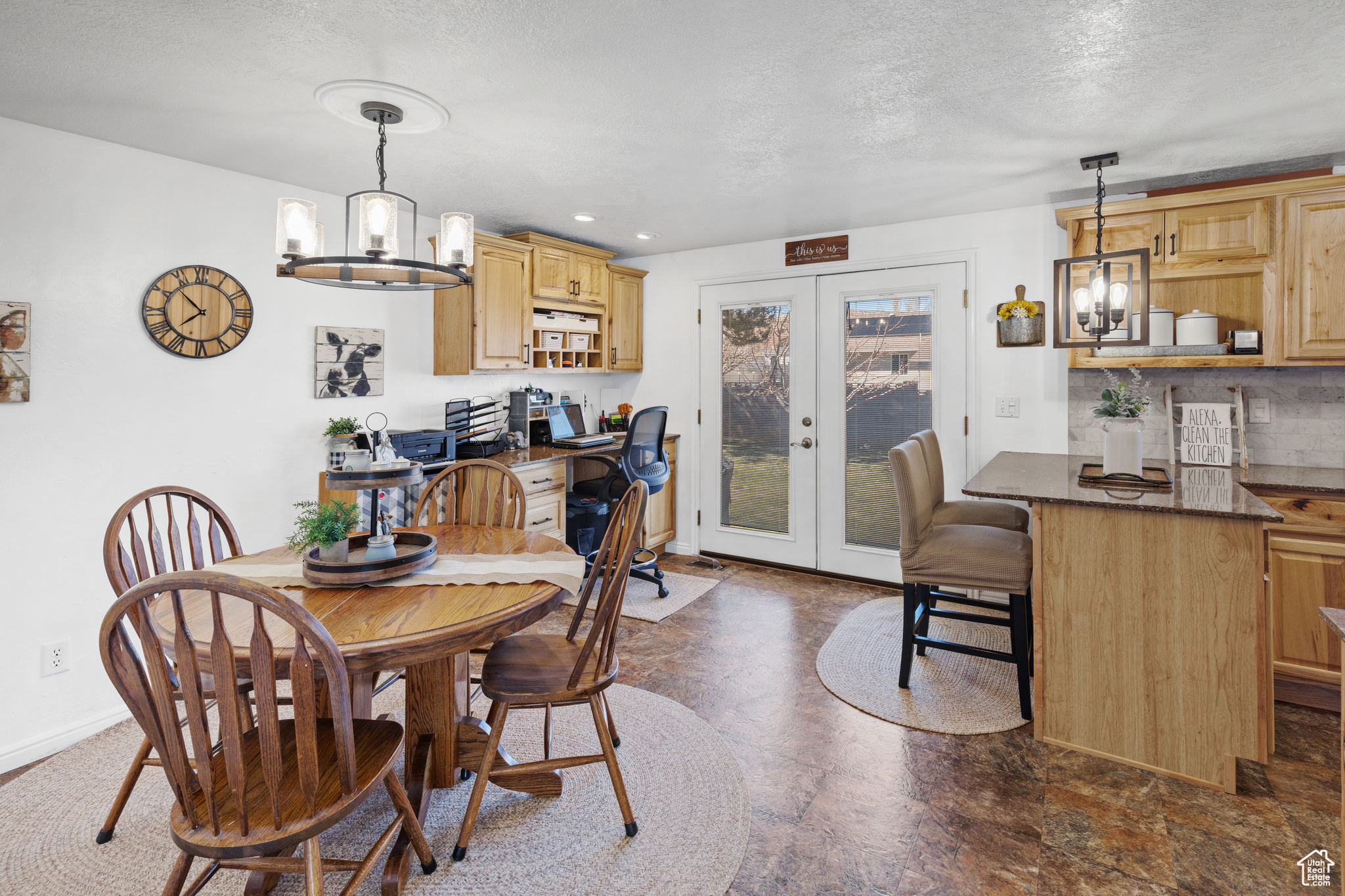 Tiled dining room with french doors, a textured ceiling, and a chandelier