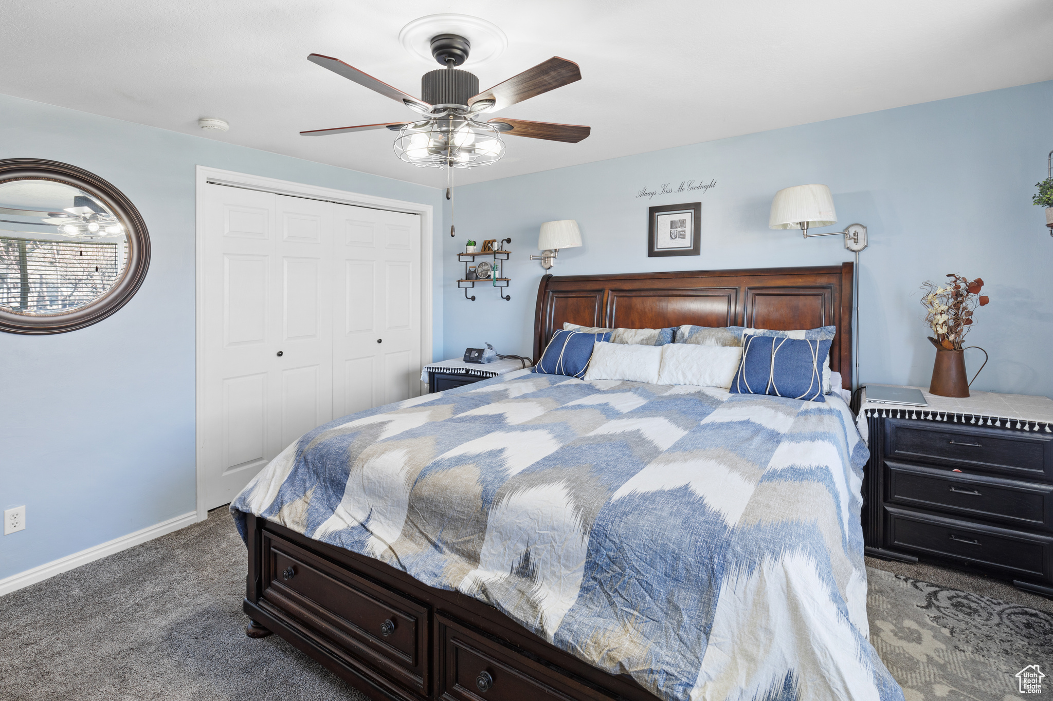 Carpeted bedroom with ceiling fan and a closet