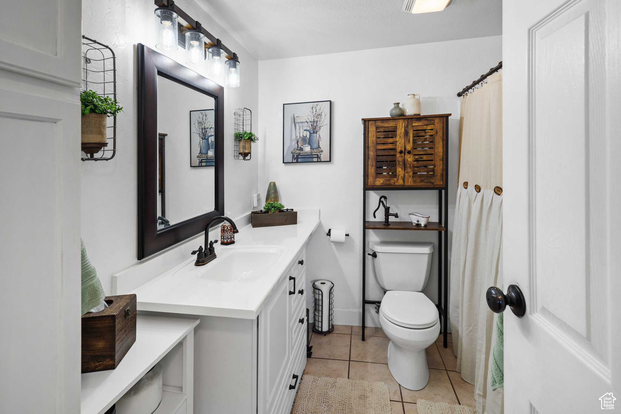 Bathroom featuring toilet, tile flooring, and vanity