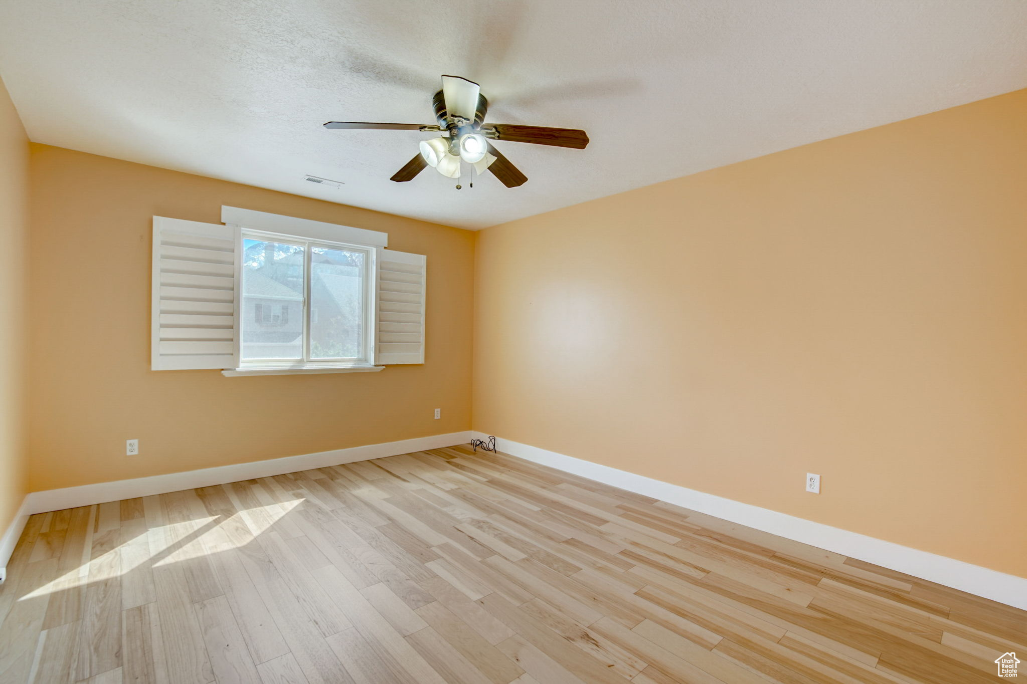 Unfurnished room with light hardwood / wood-style flooring and ceiling fan