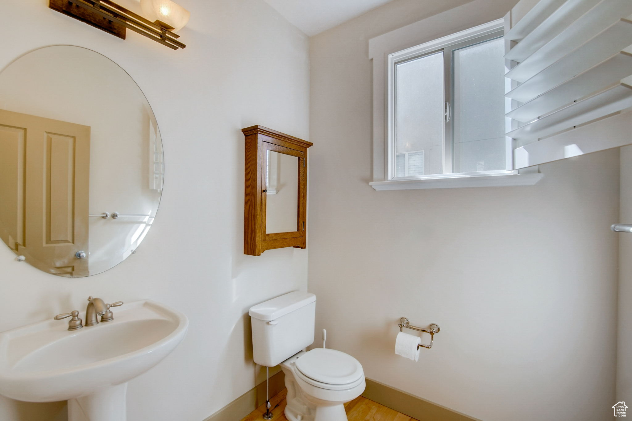 Bathroom featuring hardwood / wood-style floors, sink, and toilet