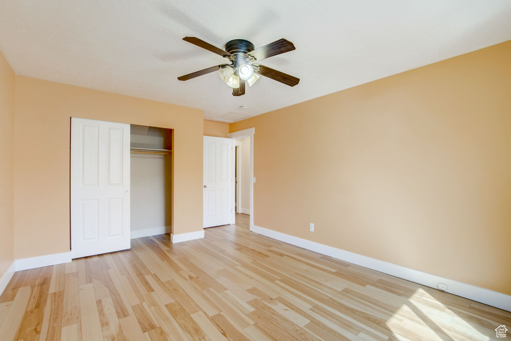 Unfurnished bedroom featuring a closet, ceiling fan, and light wood-type flooring