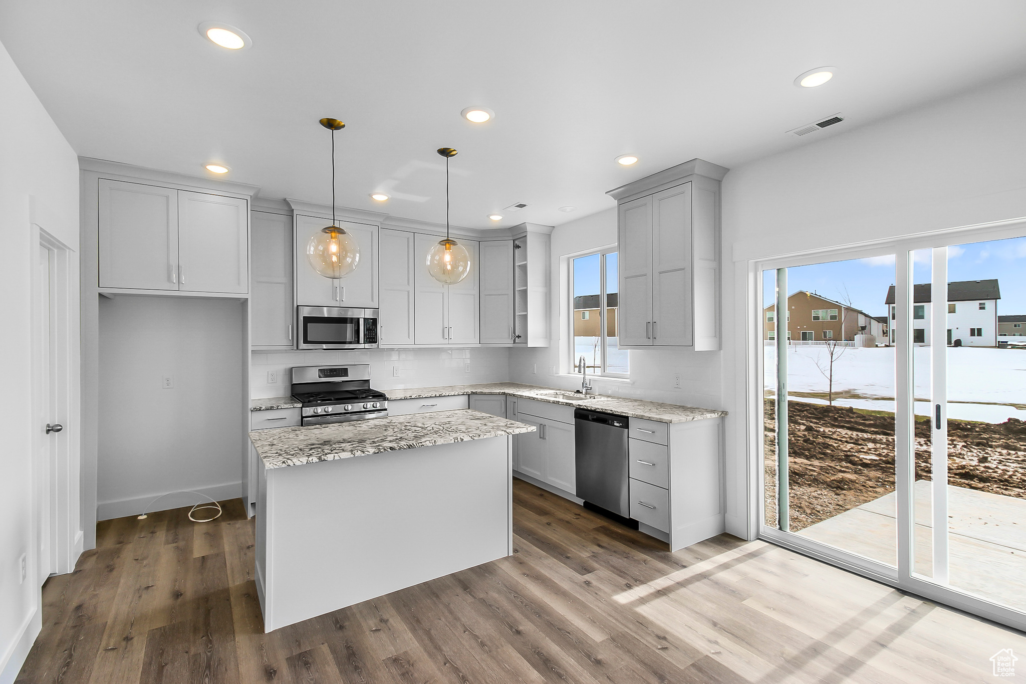 Kitchen featuring dark hardwood / wood-style floors, plenty of natural light, a kitchen island, and appliances with stainless steel finishes
