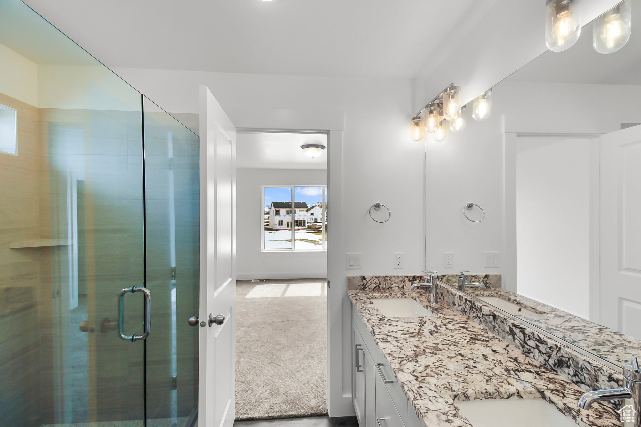 Bathroom featuring walk in shower and dual bowl vanity