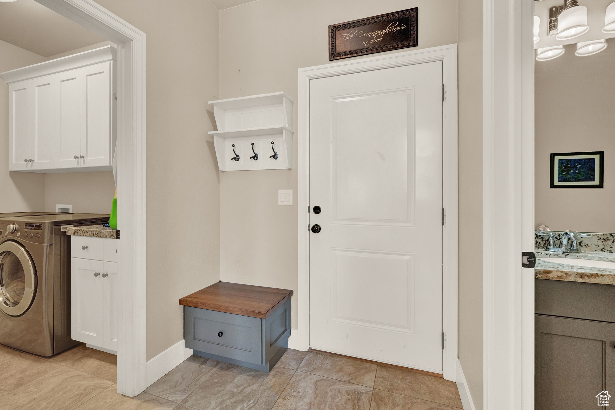 Mudroom featuring light tile floors, washer / clothes dryer, and sink