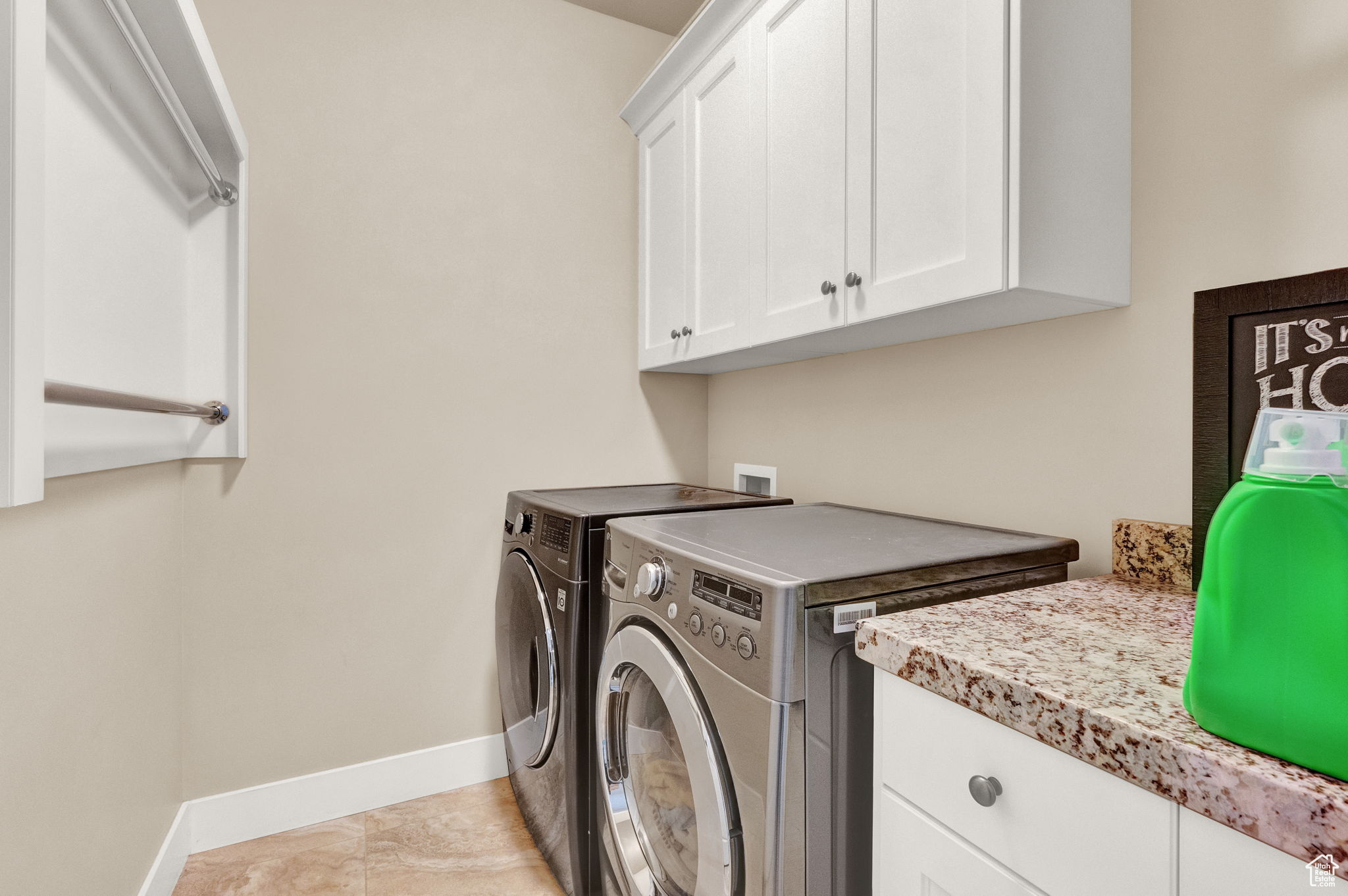 Laundry room featuring hookup for a washing machine, light tile floors, cabinets, and washer and clothes dryer