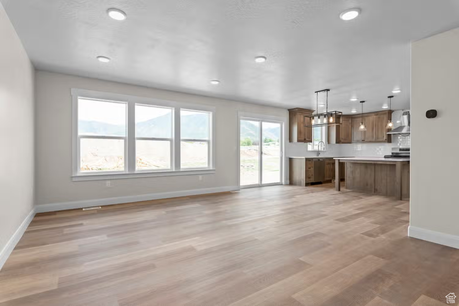 Unfurnished living room with plenty of natural light, light hardwood / wood-style floors, and sink