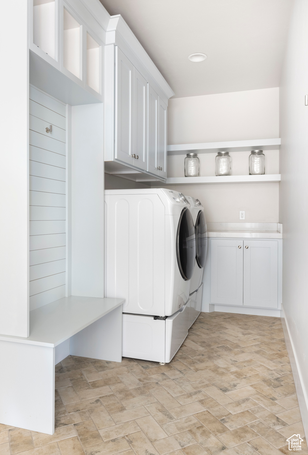 Laundry area featuring washing machine and clothes dryer and cabinets