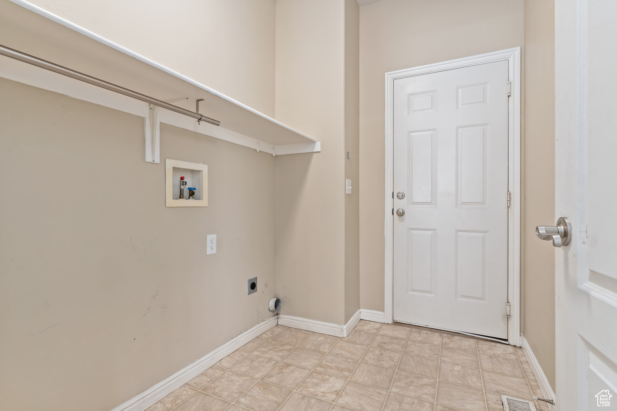 Laundry room featuring light tile floors, hookup for an electric dryer, and washer hookup