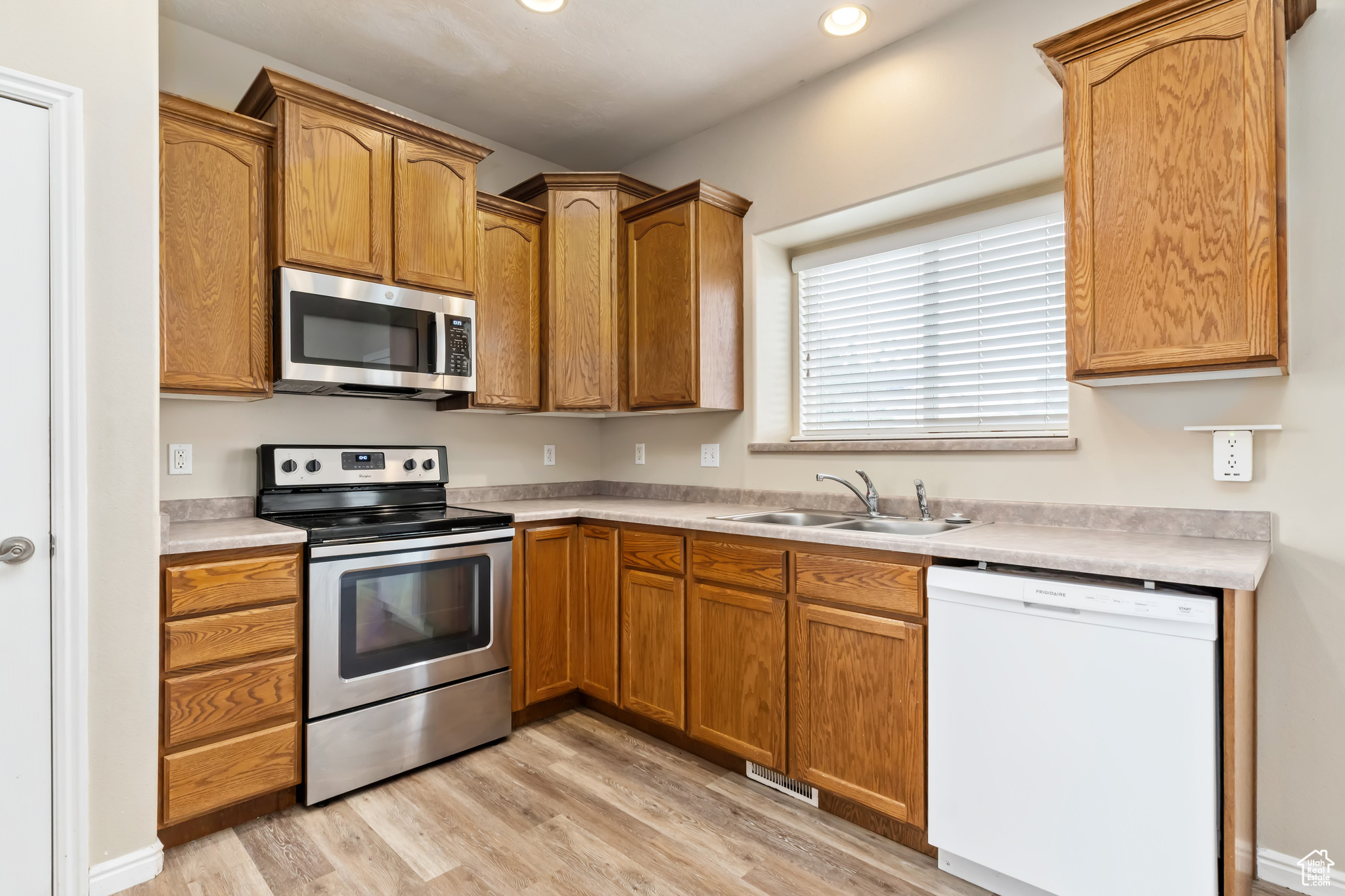 Kitchen featuring light hardwood / wood-style floors, appliances with stainless steel finishes, and sink