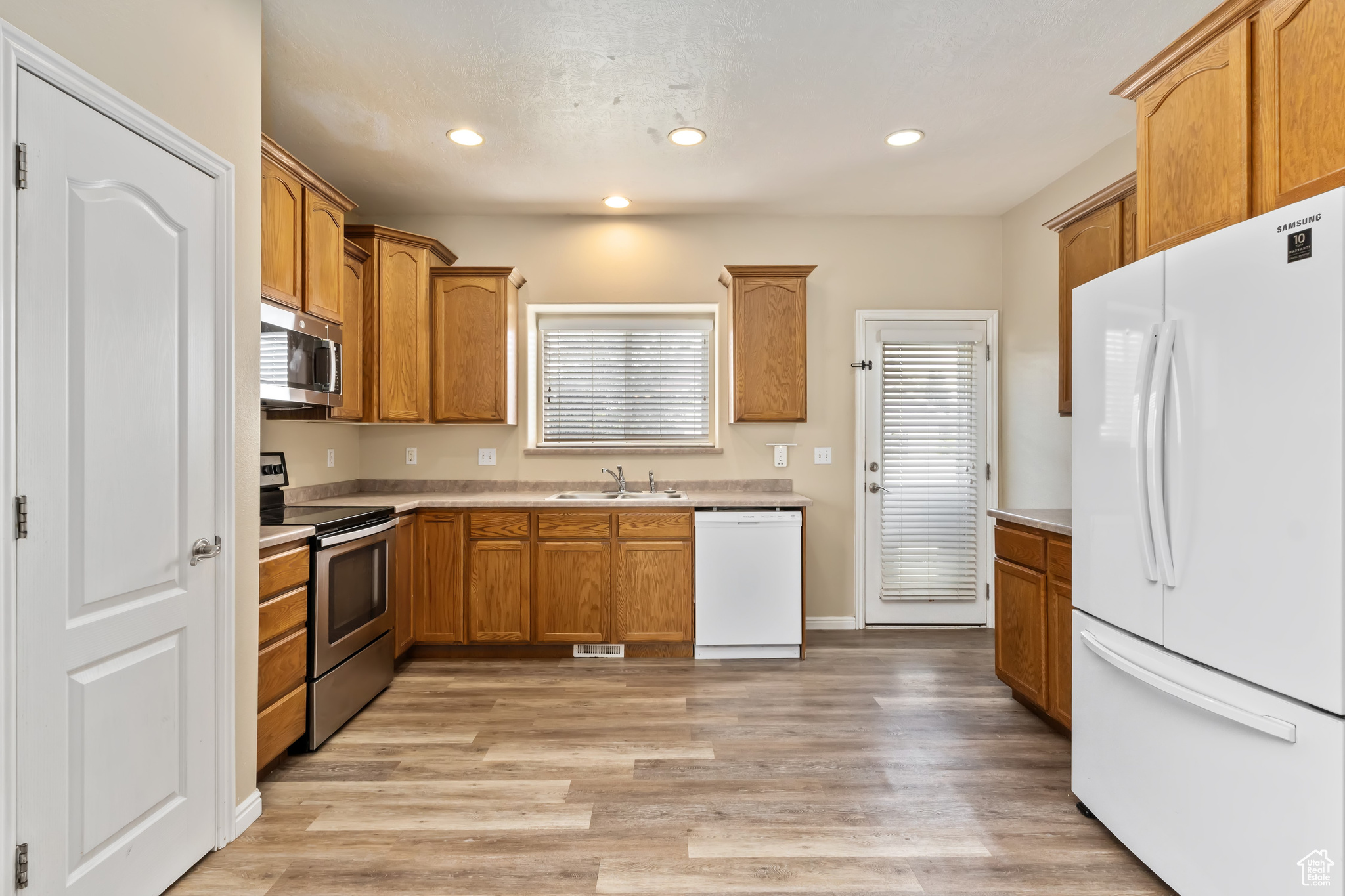 Kitchen featuring appliances with stainless steel finishes, light hardwood / wood-style floors, and sink