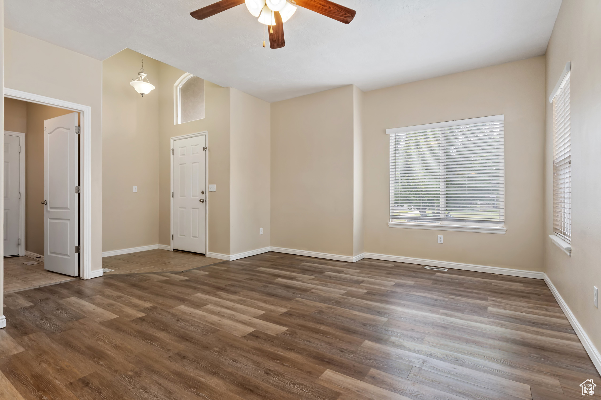 Living room with dark hardwood / wood-style flooring and ceiling fan