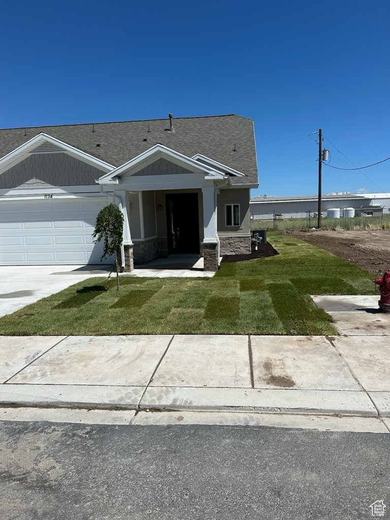 View of front facade with a front yard and a garage