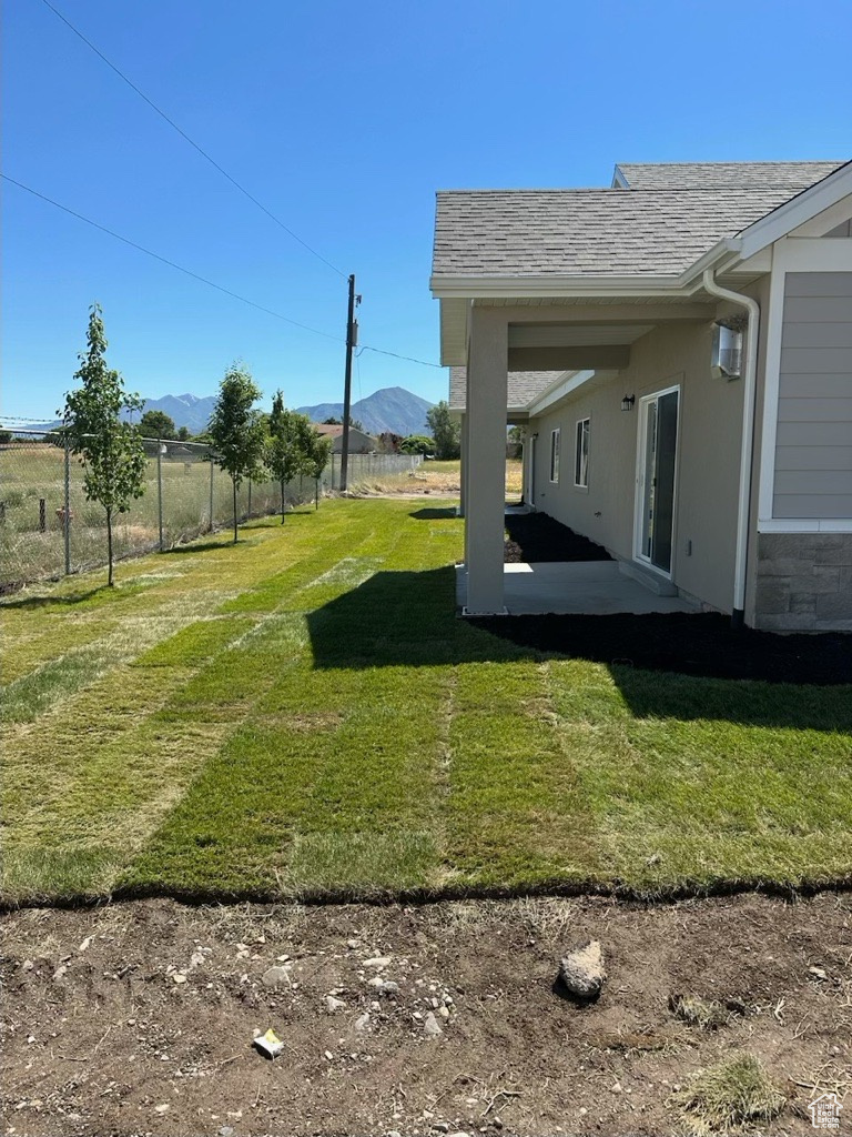 View of yard with a mountain view. White vinyl fence has now been installed.