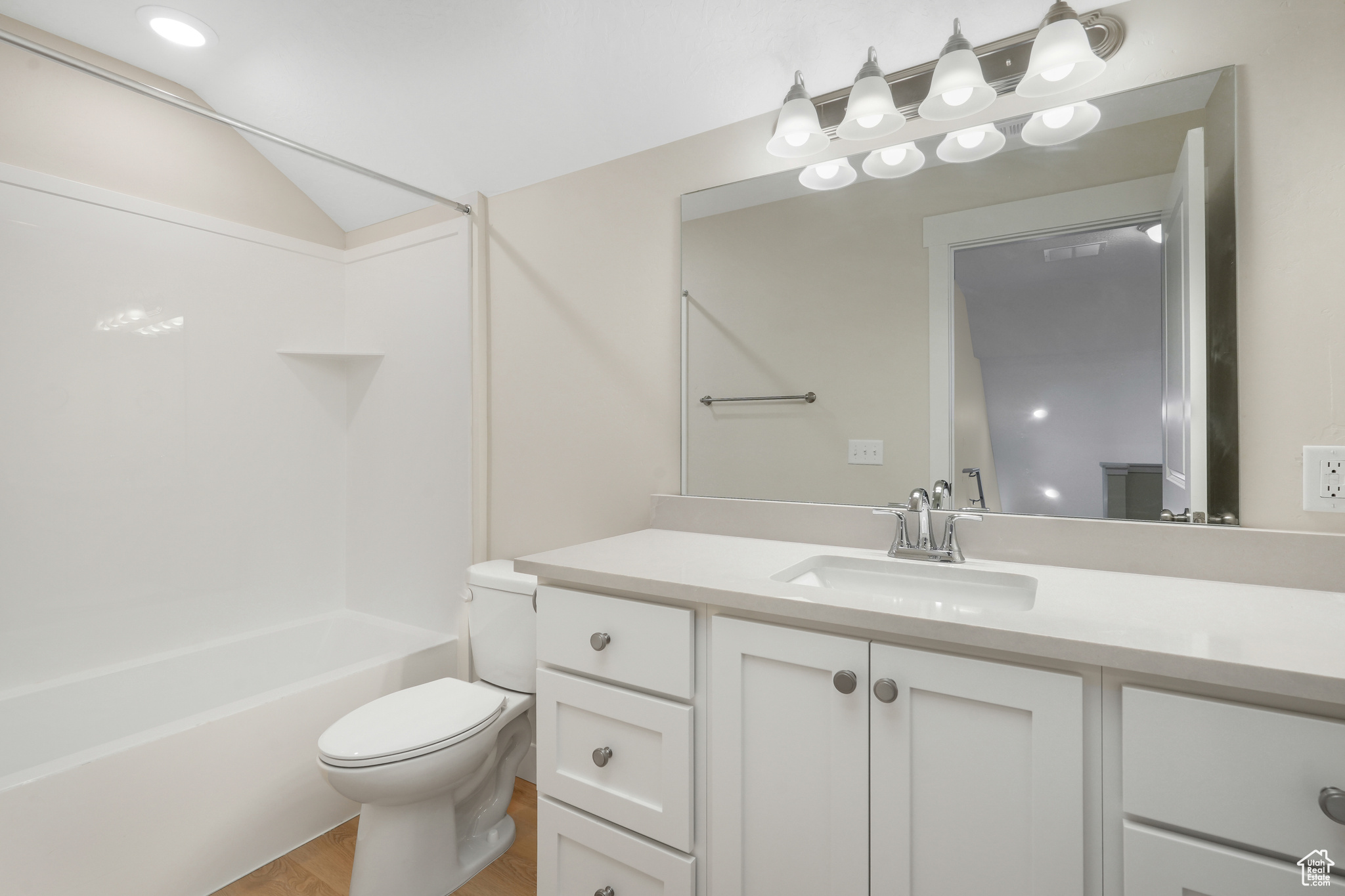 Full bathroom featuring  shower combination, toilet, large vanity, and hardwood / wood-style flooring
