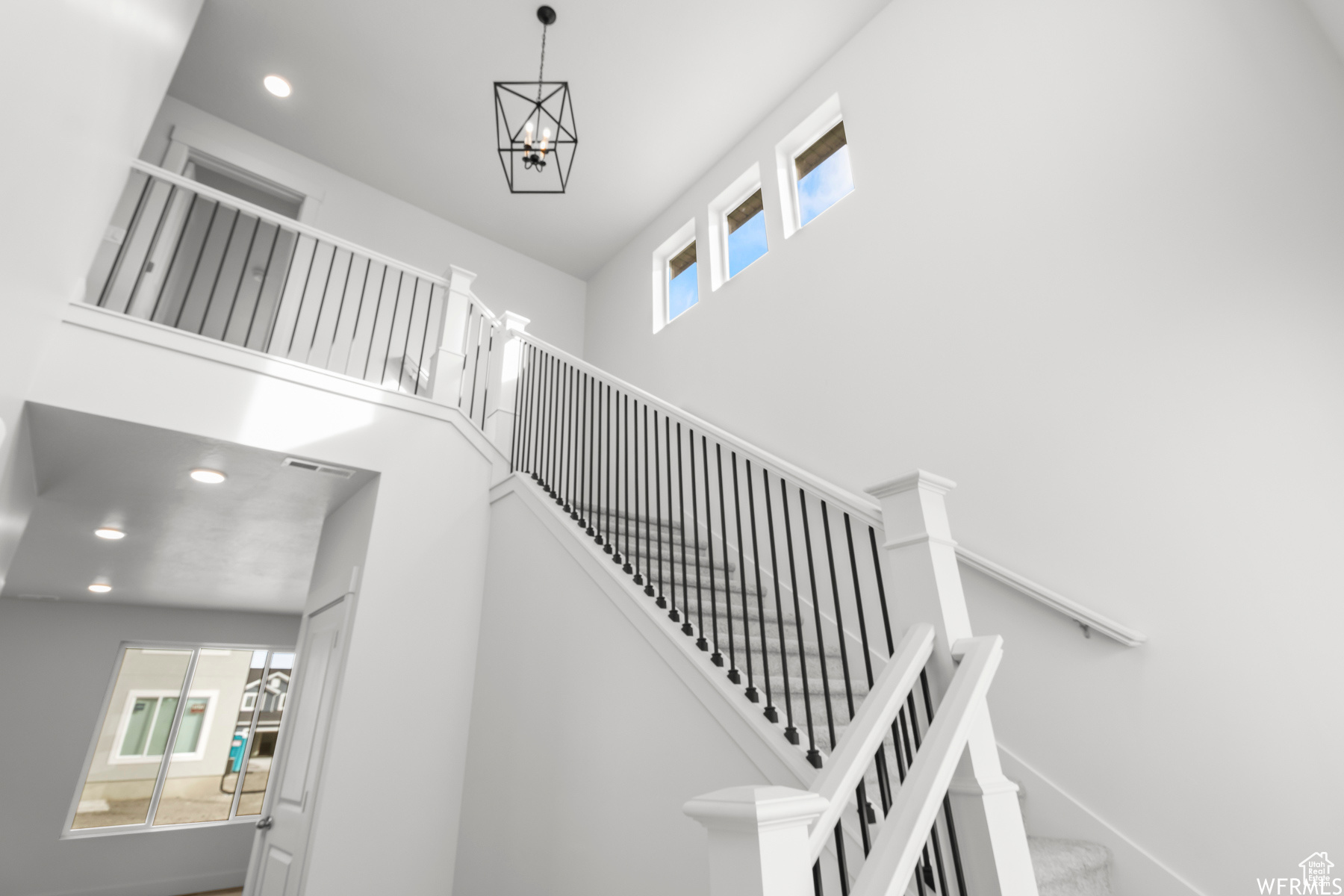 Stairs featuring a high ceiling and a chandelier