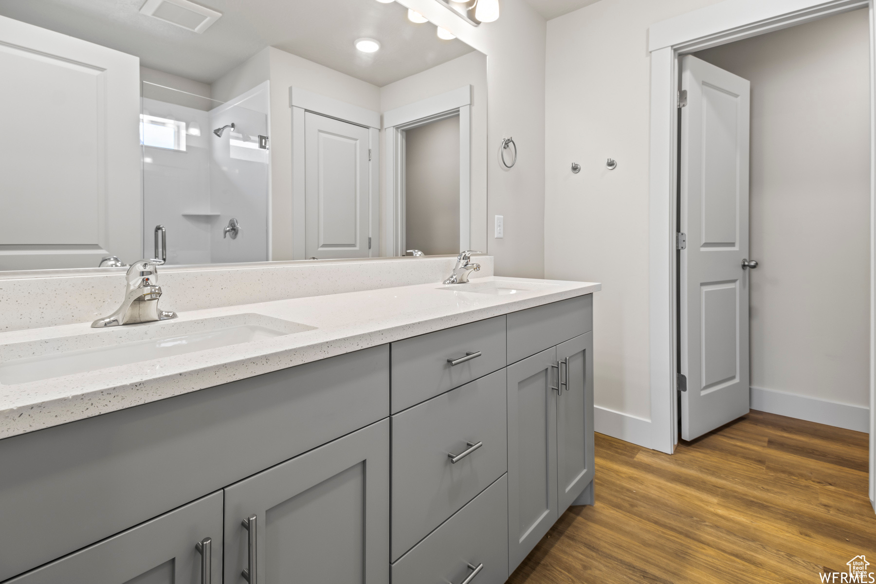 Bathroom with dual sinks, hardwood / wood-style flooring, and large vanity