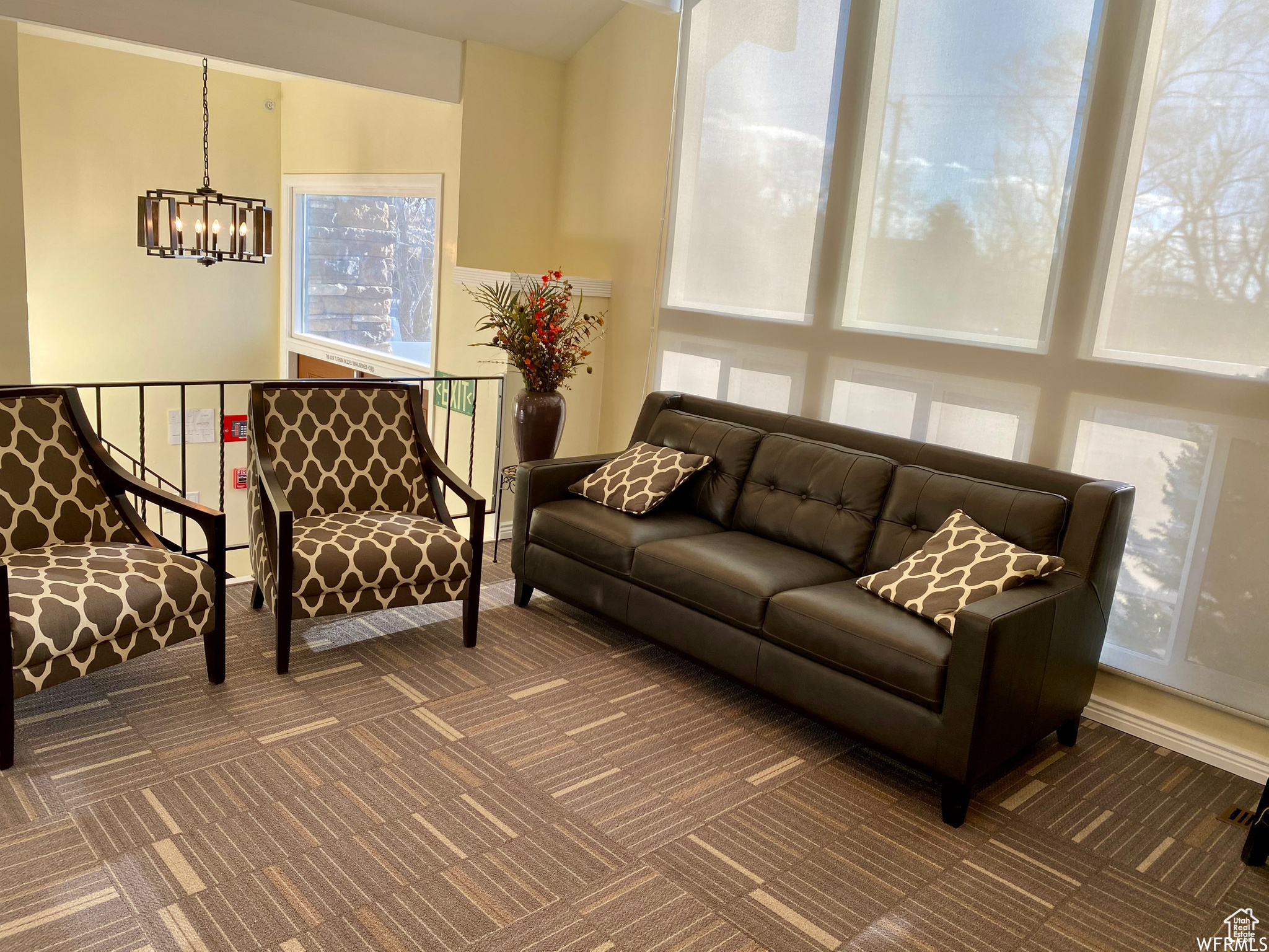 Living room with dark colored carpet and a chandelier