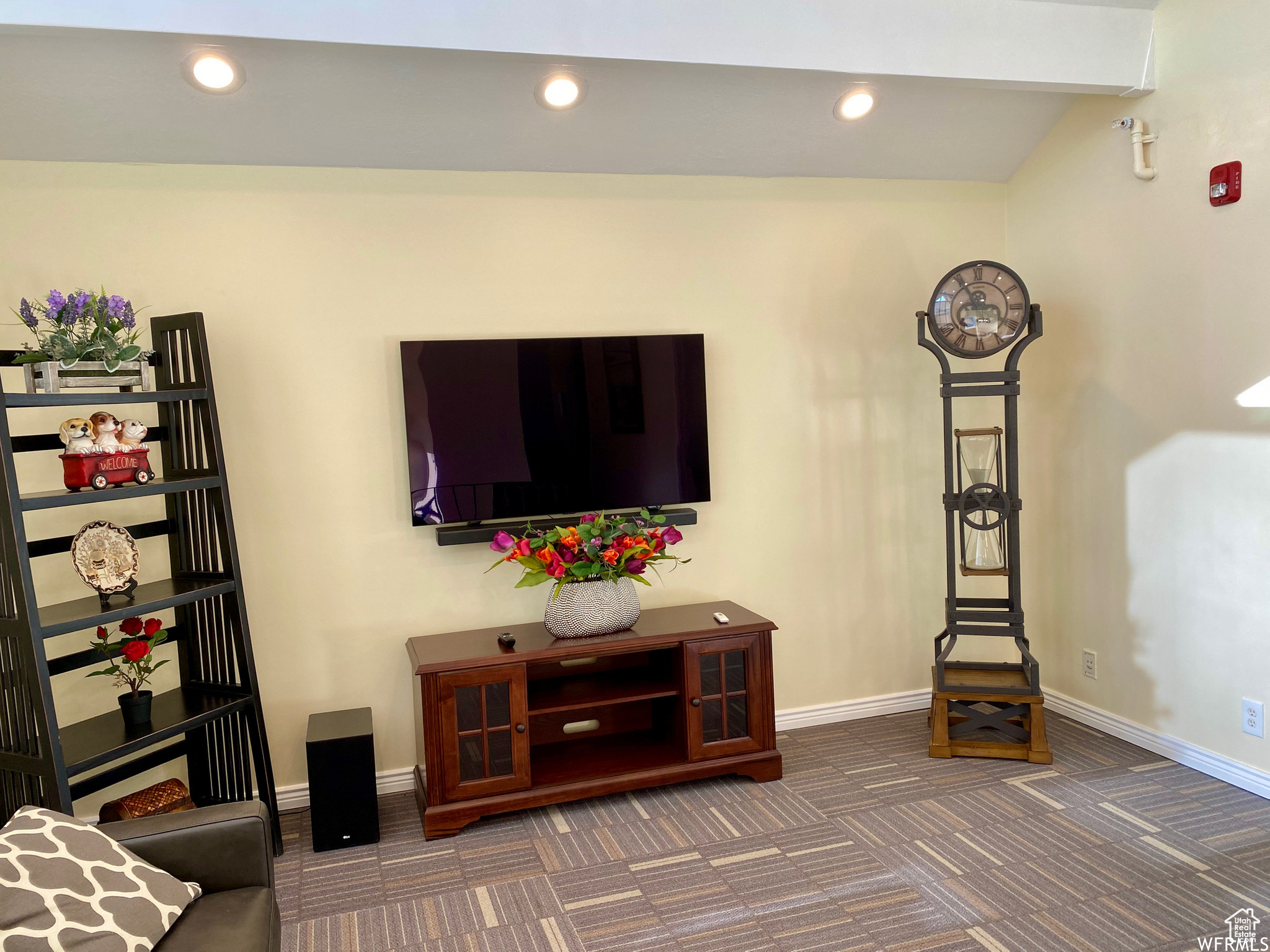 Carpeted living room with vaulted ceiling with beams