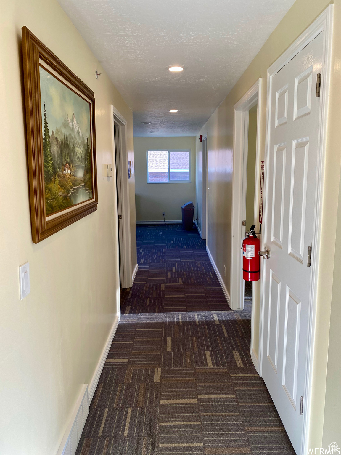 Corridor featuring a textured ceiling