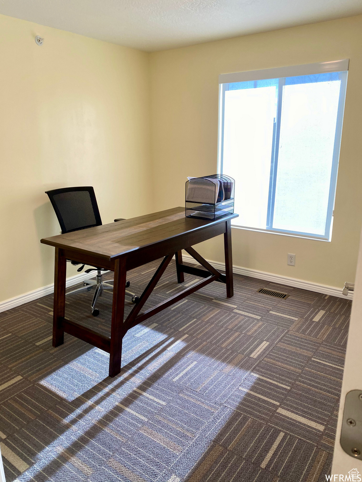 Office space featuring dark colored carpet