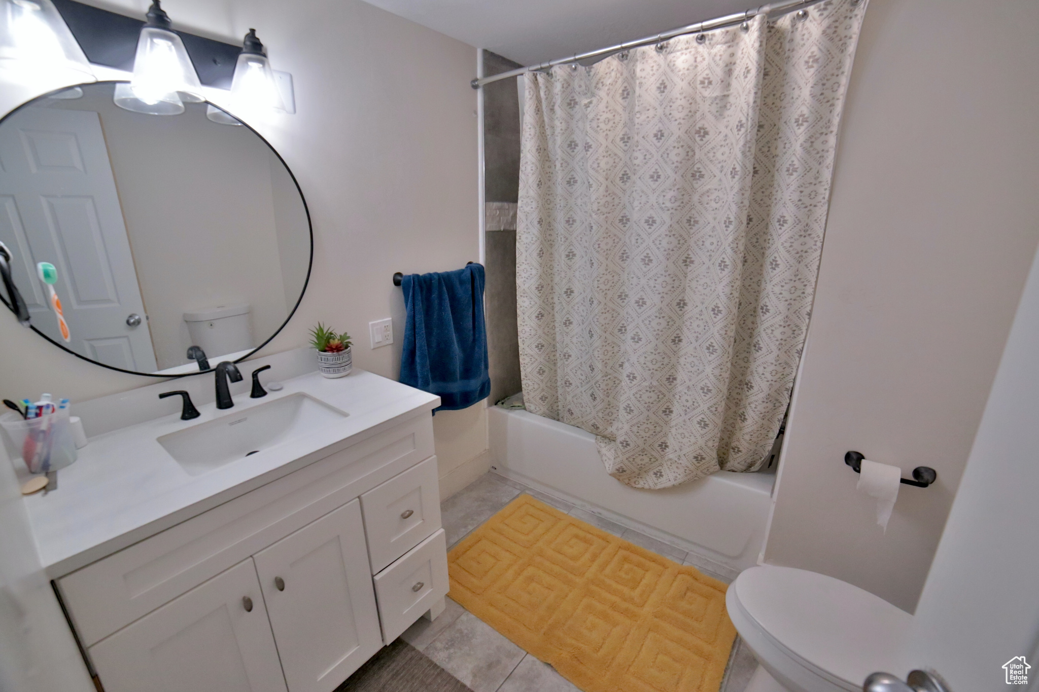Full bathroom featuring shower / bath combination with curtain, tile floors, toilet, and oversized vanity