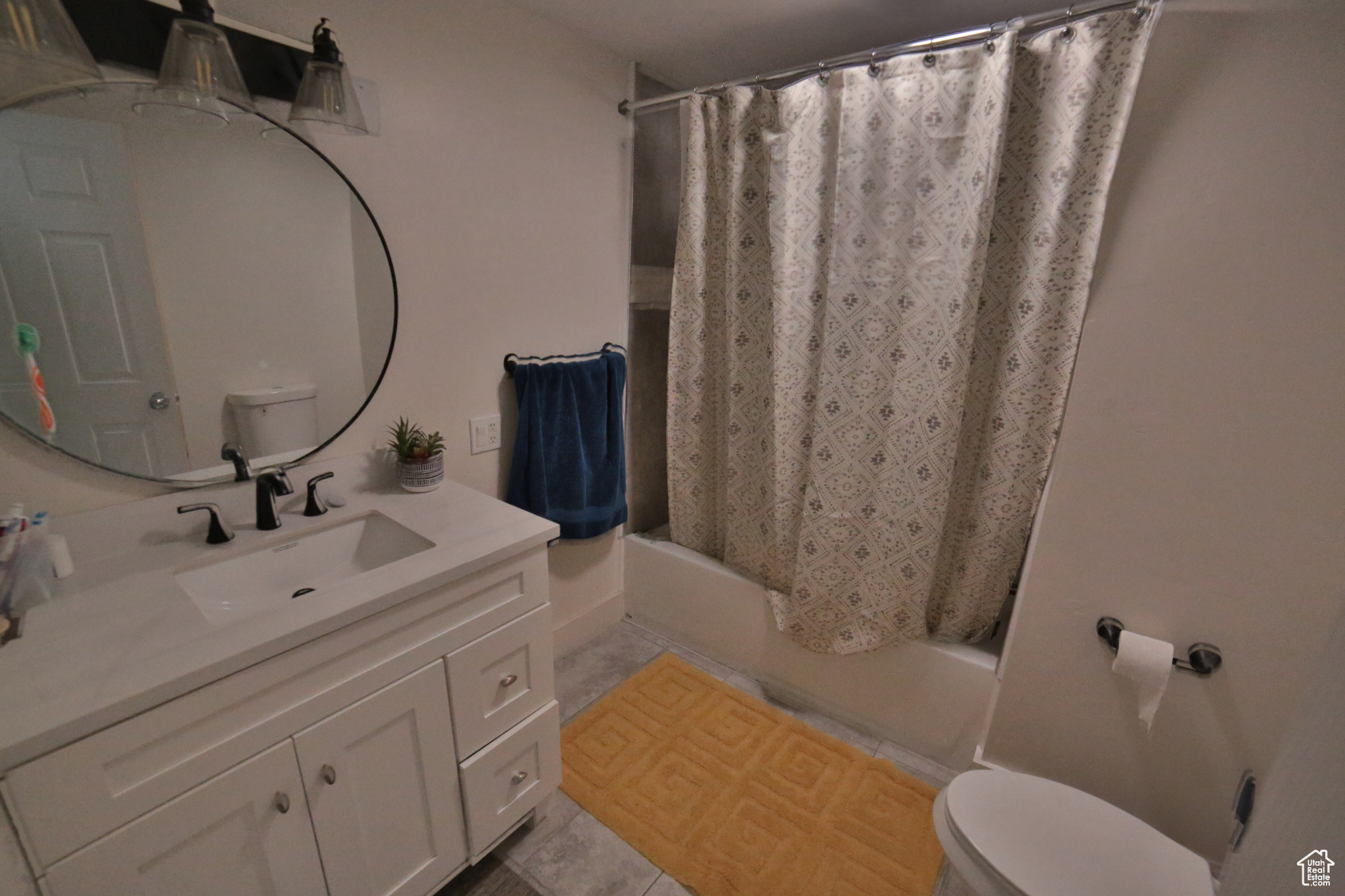 Full bathroom with toilet, tile flooring, shower / tub combo with curtain, and vanity