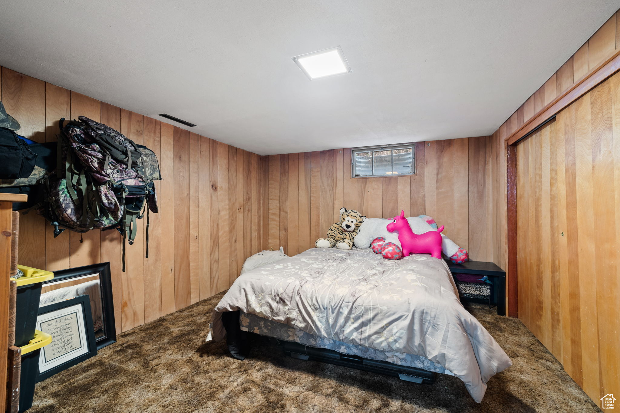 Carpeted bedroom featuring wooden walls