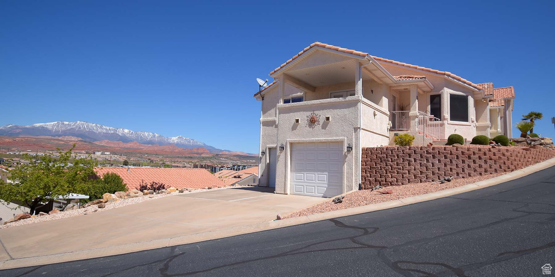 View of front of property with a balcony, a mountain view, and a garage