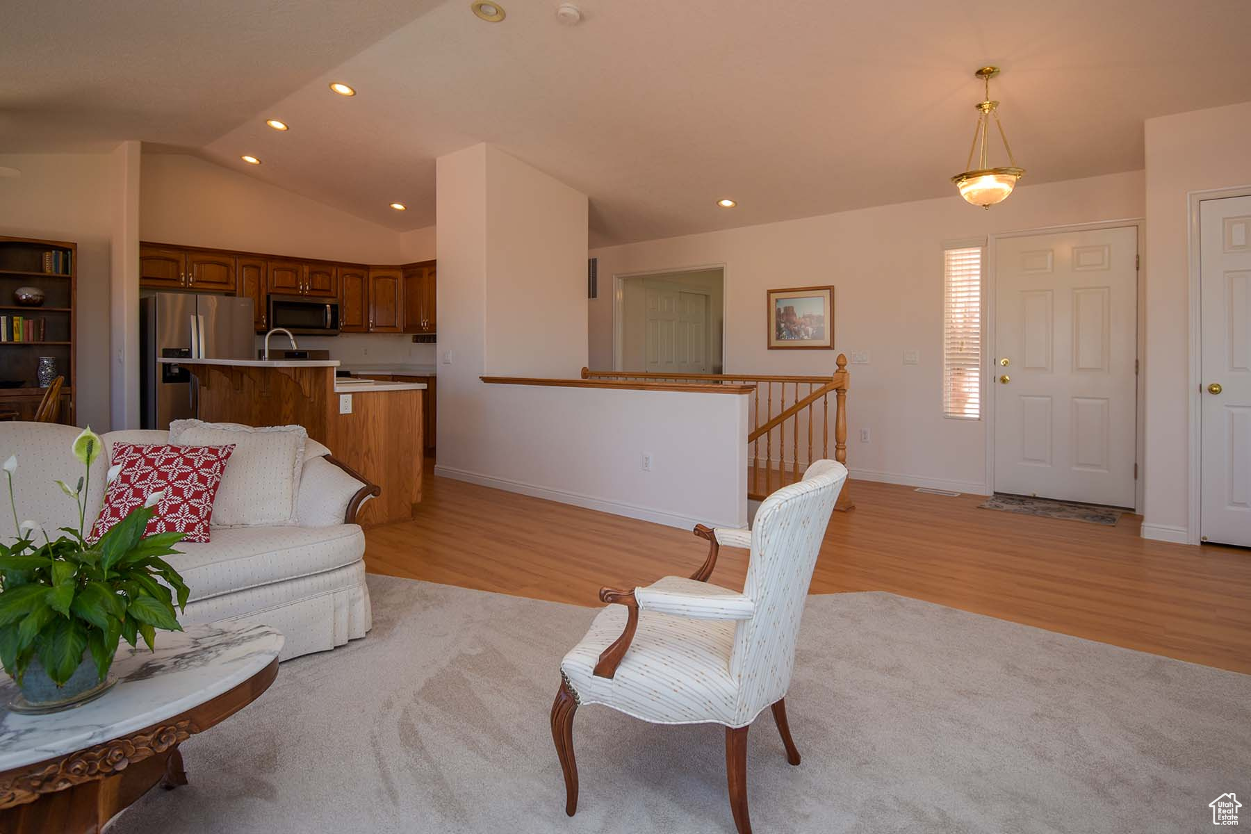 Living room, light hardwood / wood-style floors, and vaulted ceiling