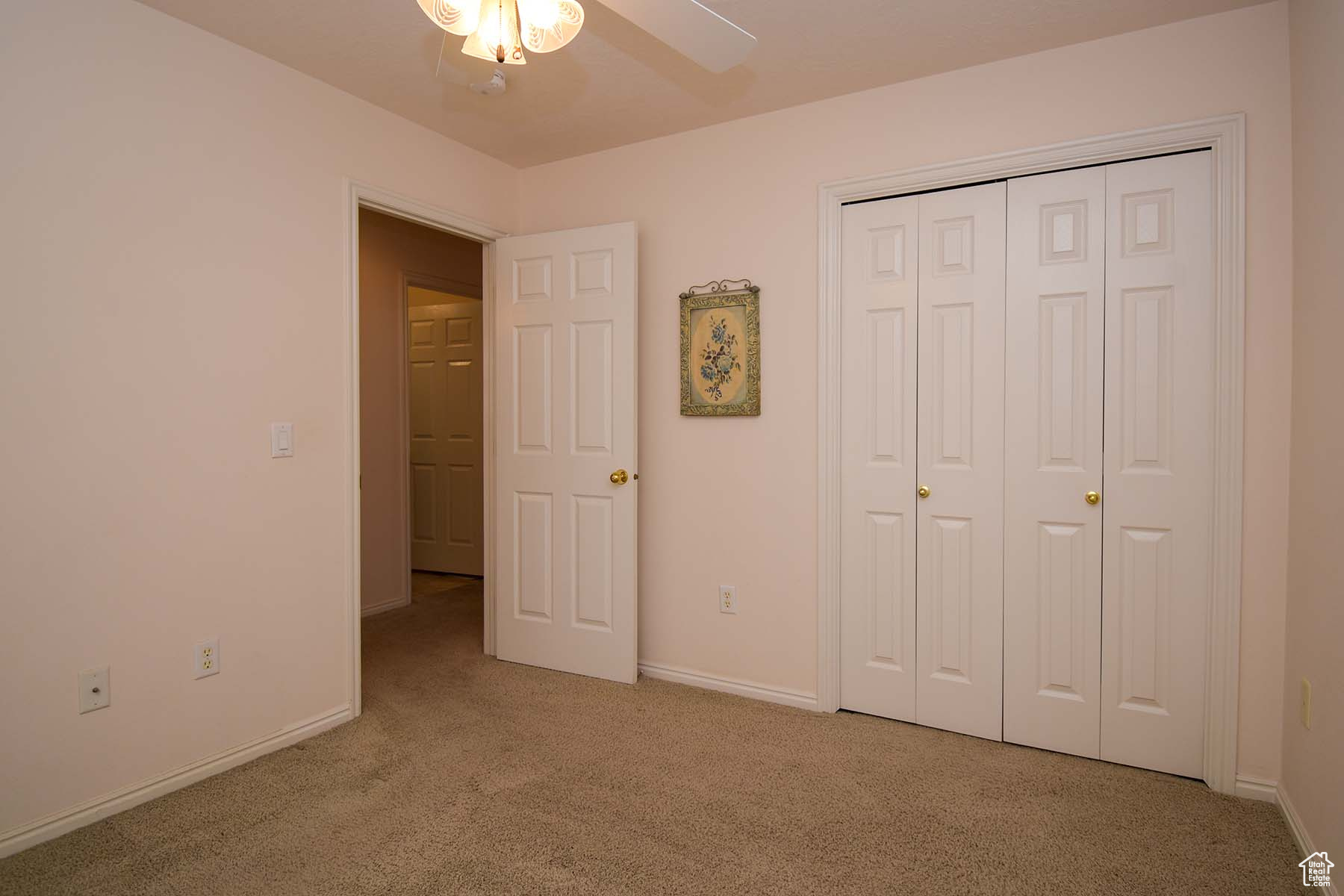 Guest bedroom with a closet, light carpet
