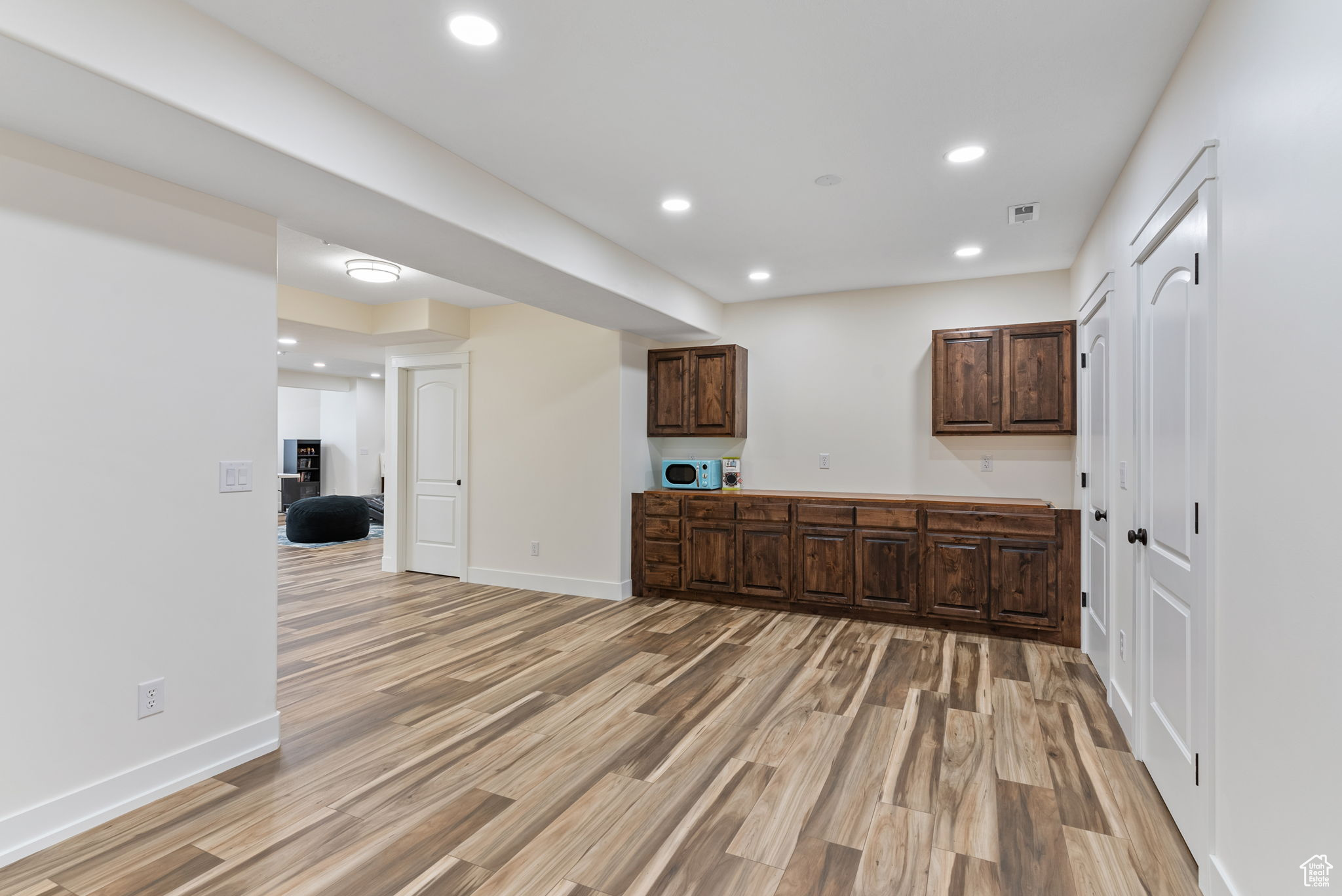 Kitchen featuring dark brown cabinets and wood-type flooring