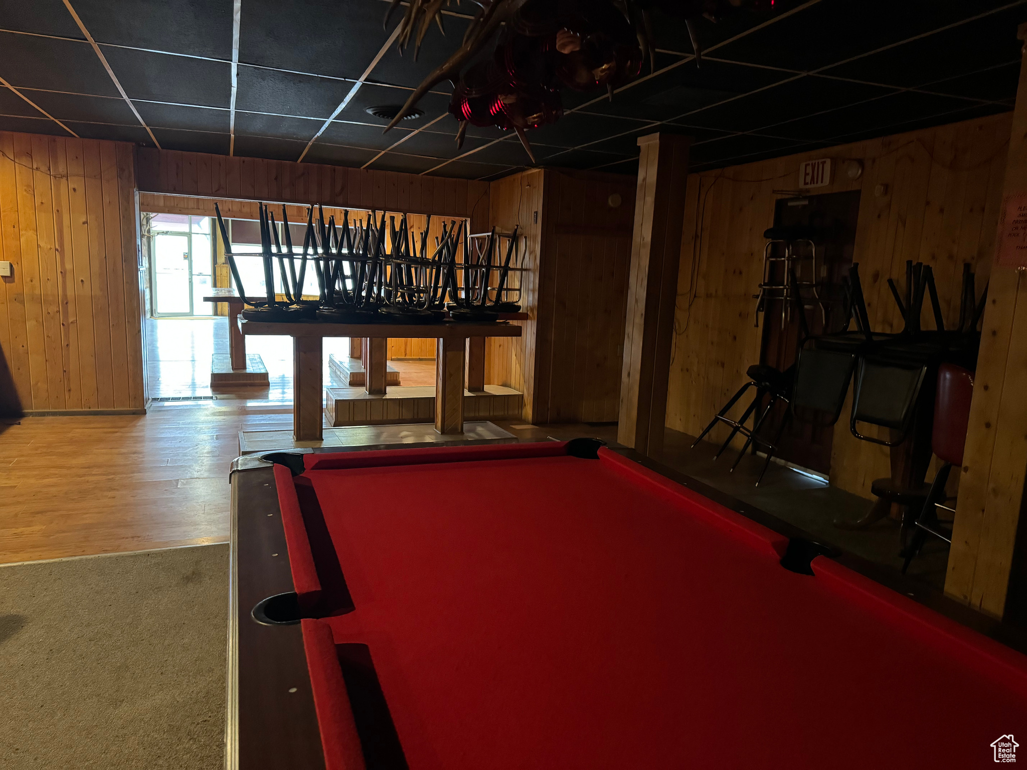 Game room with wooden walls, pool table, and carpet flooring