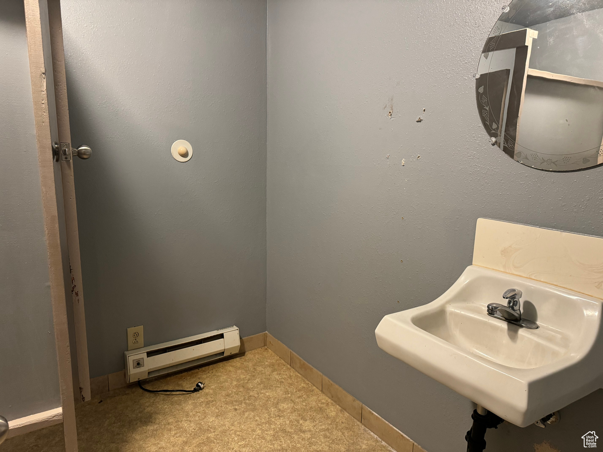 Bathroom featuring baseboard heating and sink