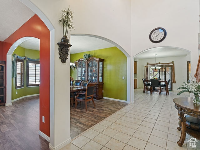Entrance foyer with lofted ceiling, a chandelier, light tile floors, and plenty of natural light