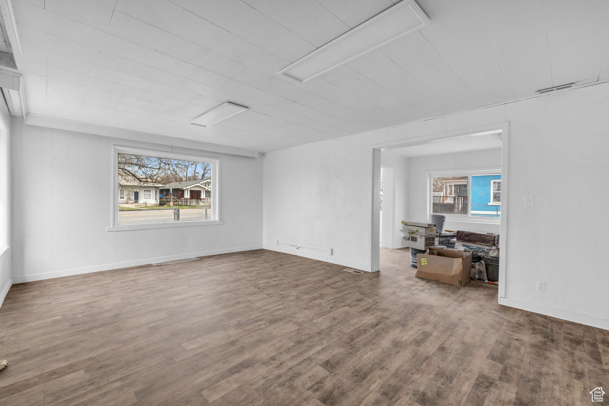 Unfurnished room featuring plenty of natural light and dark hardwood / wood-style floors