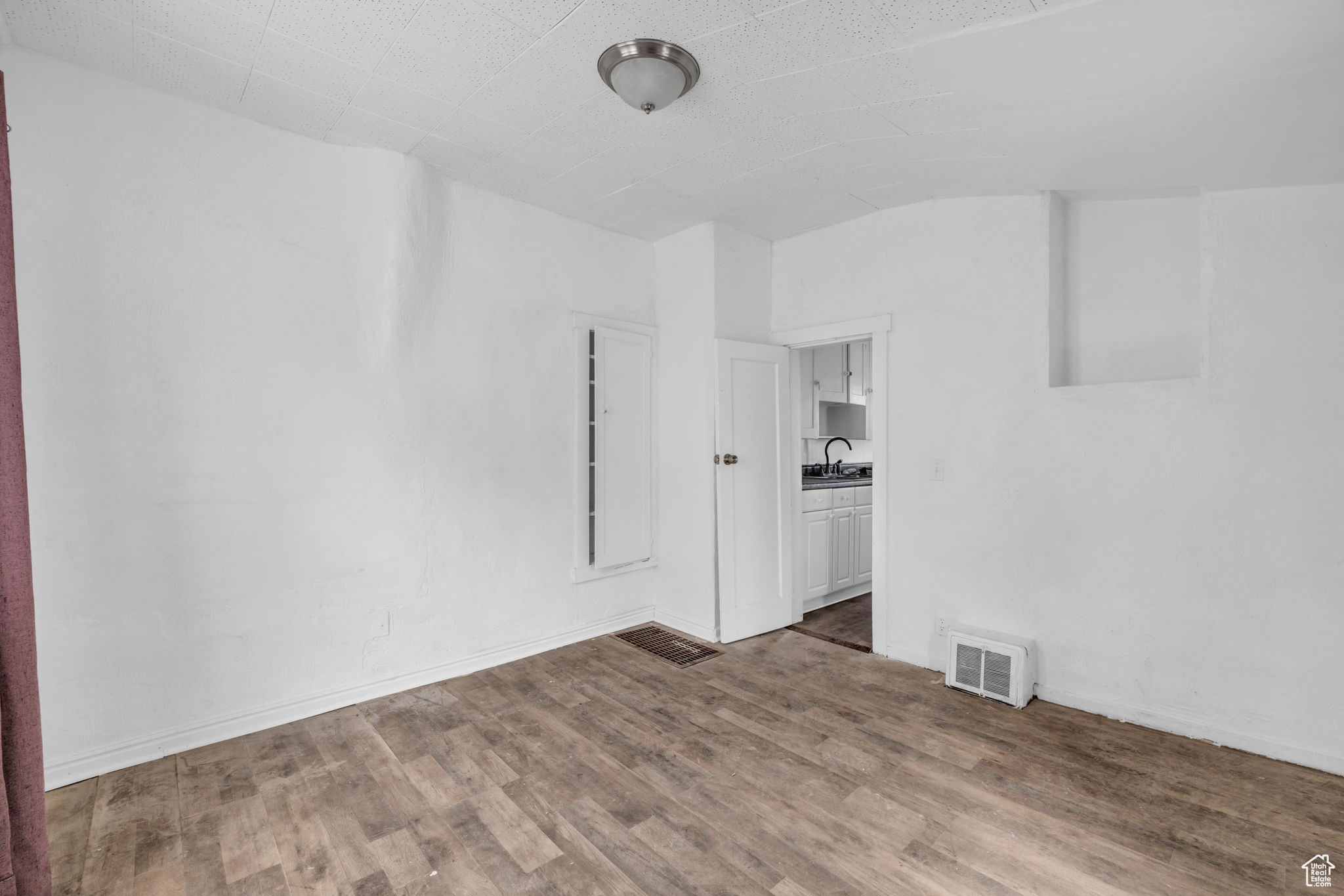 Empty room with dark hardwood / wood-style floors and sink