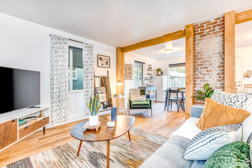 Living room featuring brick wall and light hardwood / wood-style floors