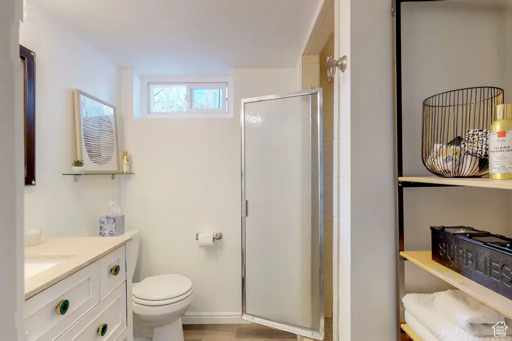 Bathroom with toilet, hardwood / wood-style floors, vanity, and walk in shower