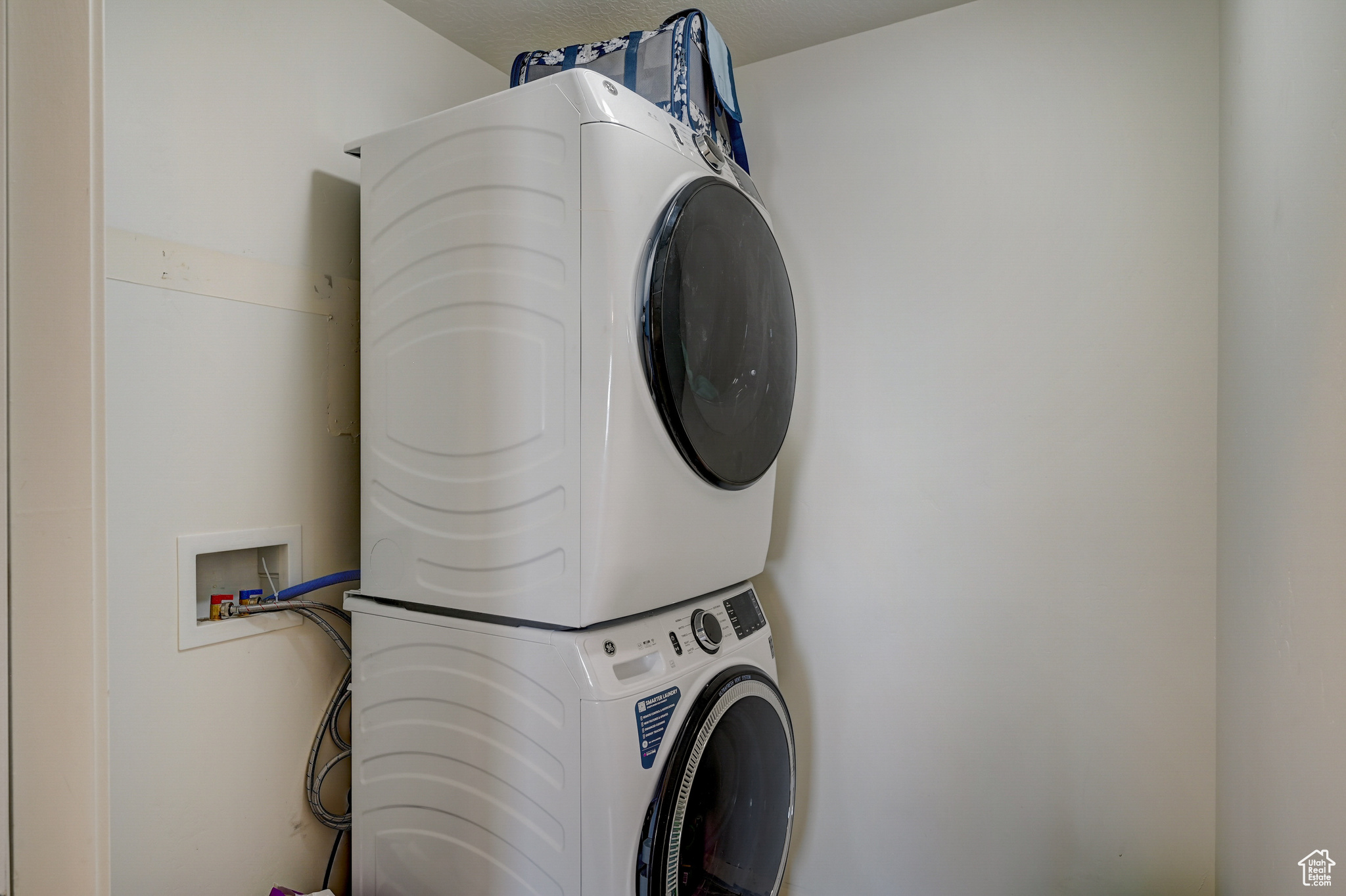 Clothes washing area with stacked washing maching and dryer and washer hookup