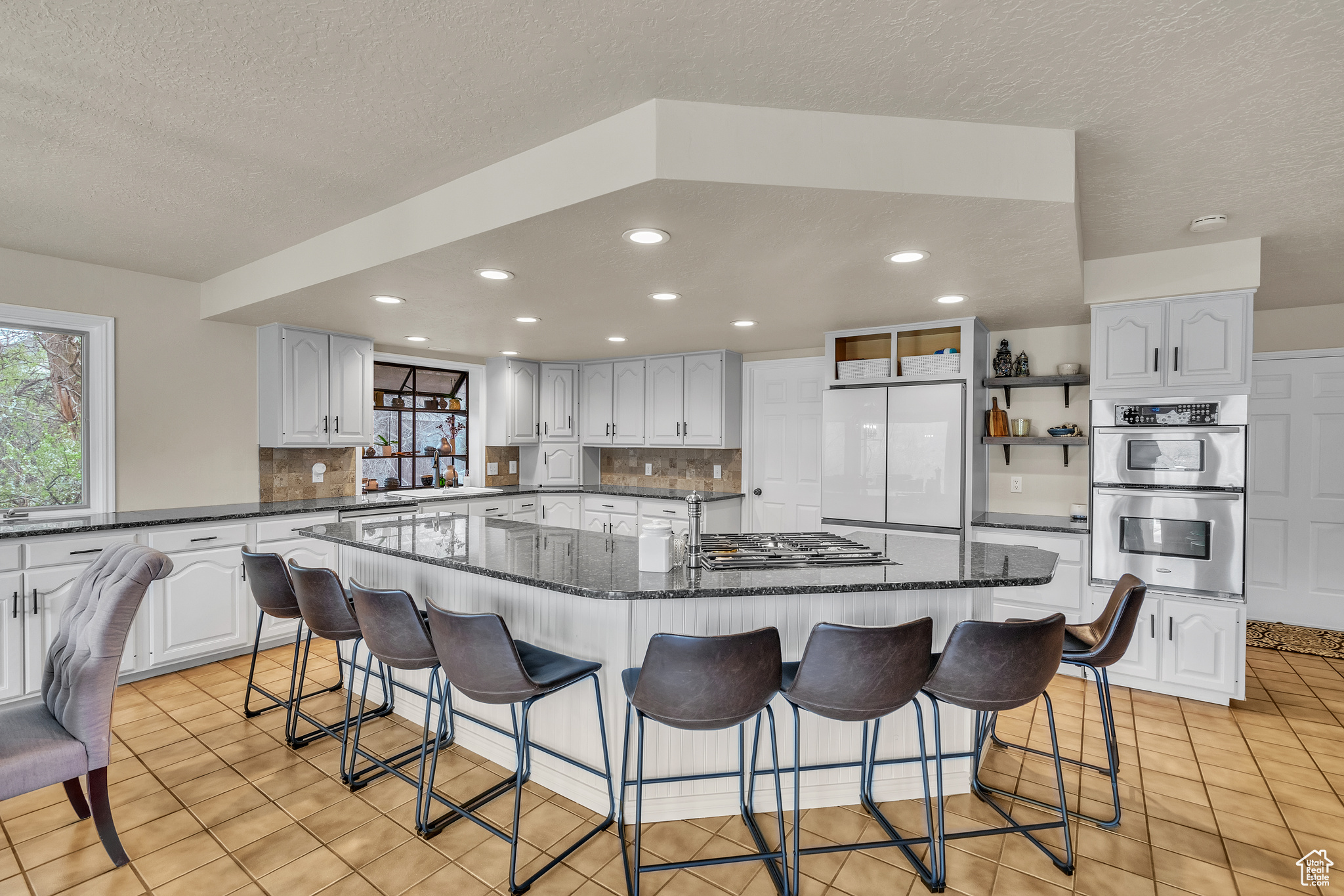 Kitchen featuring backsplash, a kitchen island, a breakfast bar area, and stainless steel appliances