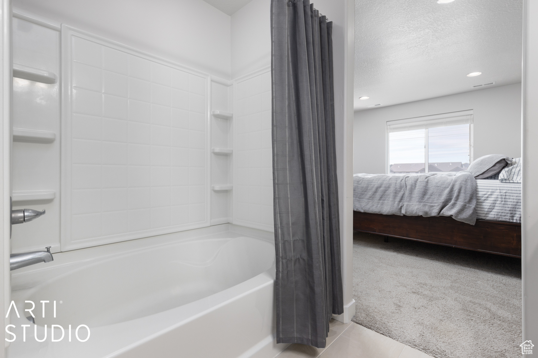 Bathroom featuring shower / bath combo with shower curtain, tile floors, and a textured ceiling