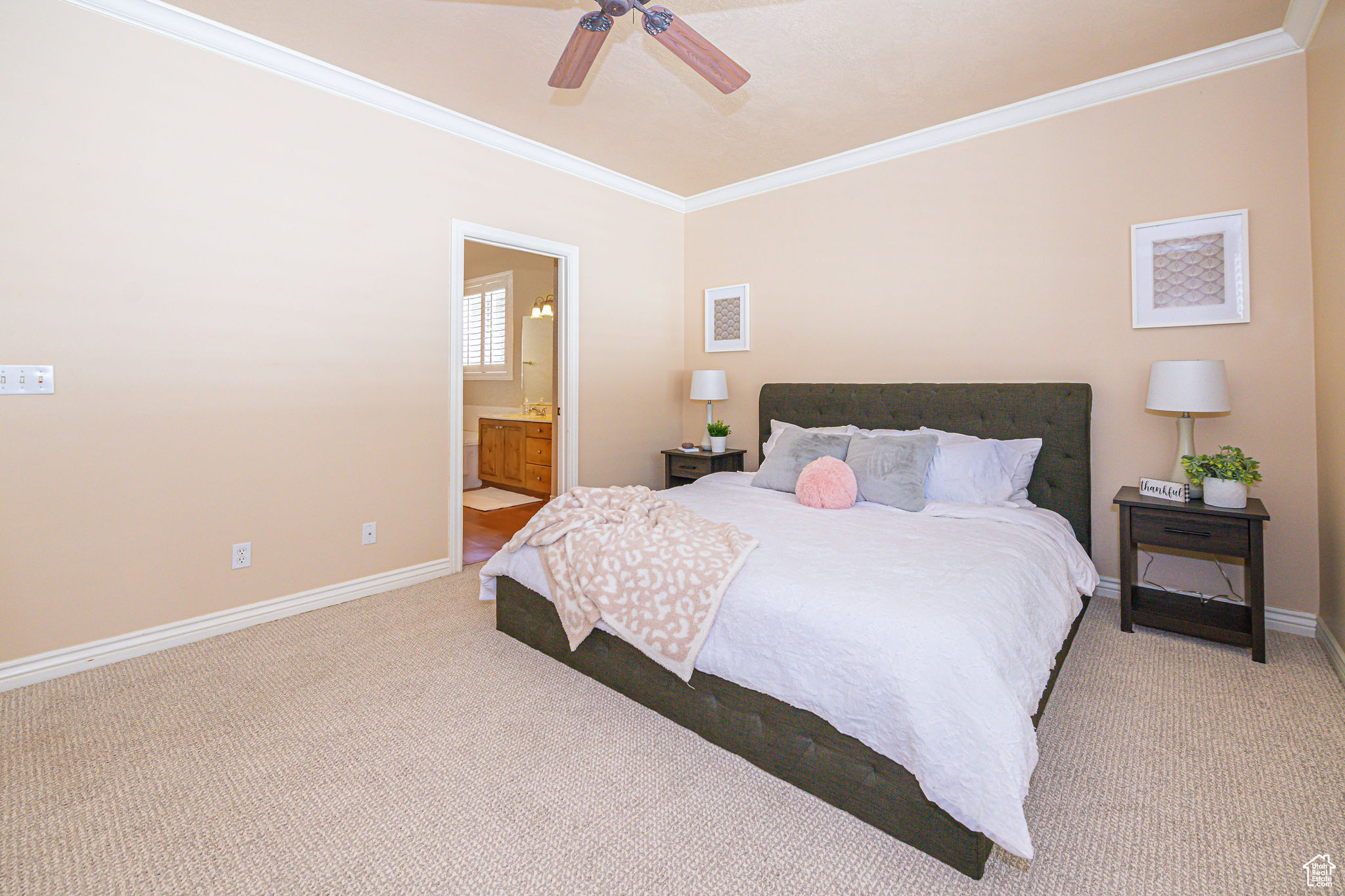 Carpeted bedroom with ornamental molding, ceiling fan, and ensuite bathroom