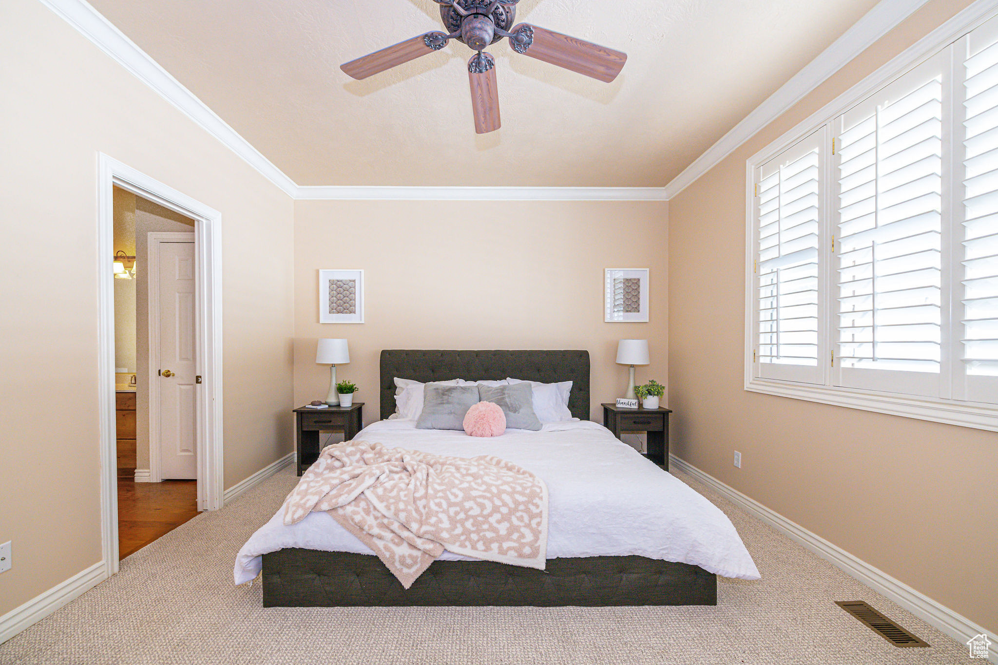 Bedroom with ceiling fan, crown molding, and carpet flooring