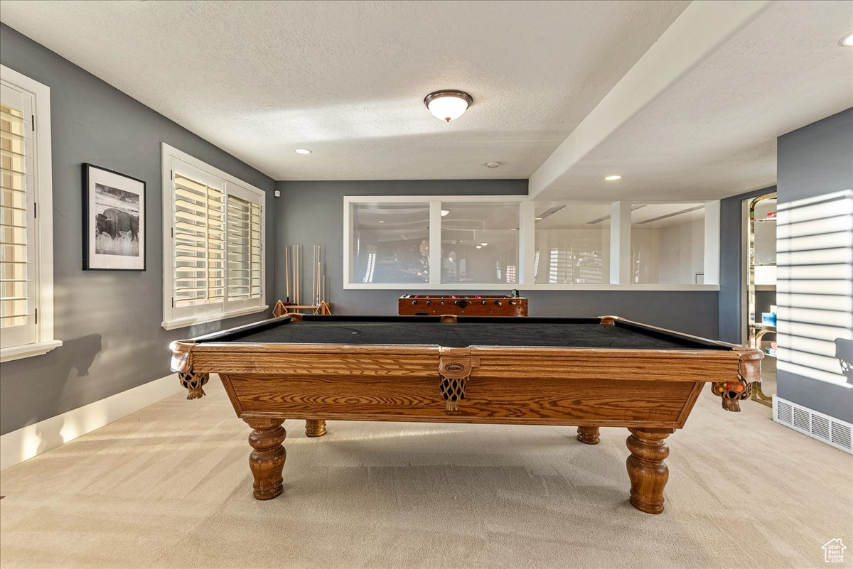 Rec room with billiards, a textured ceiling, and light carpet