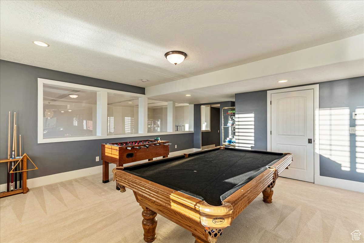 Playroom with light carpet, a textured ceiling, and billiards