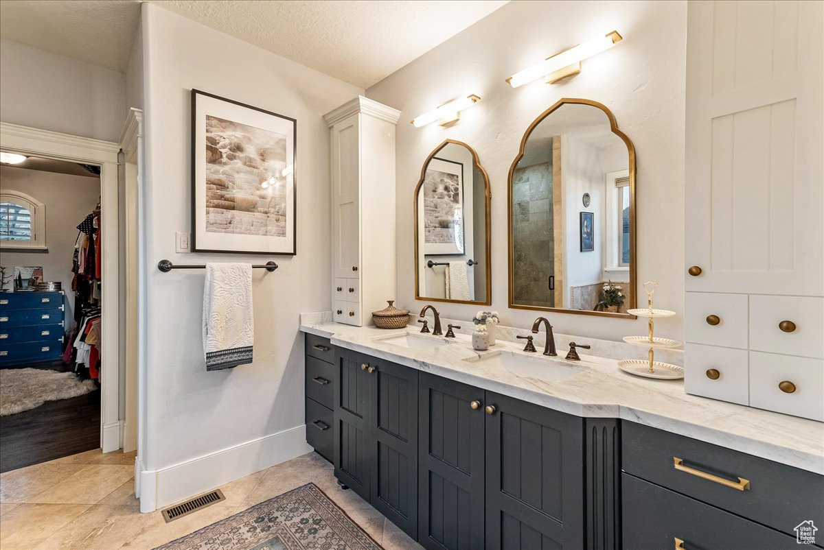 Bathroom featuring engineered hardwood flooring, oversized vanity, and a textured ceiling