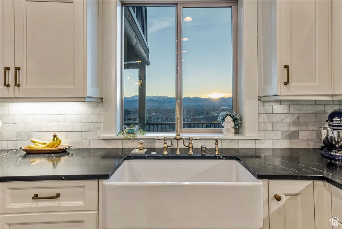 Kitchen featuring white cabinets, a mountain view, and tasteful backsplash